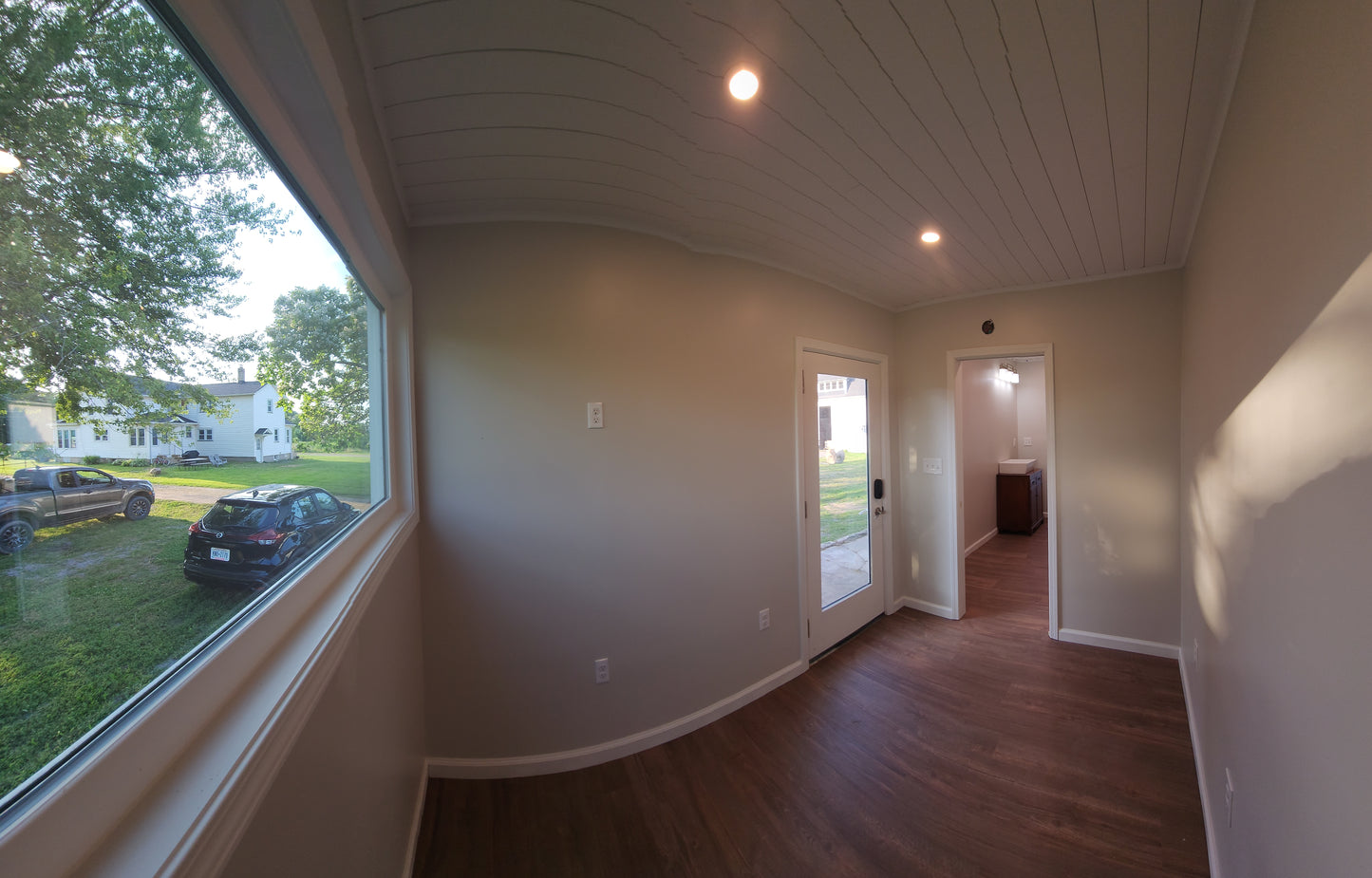 Room with large window, wood pattern floor, and with a great view of the yard.