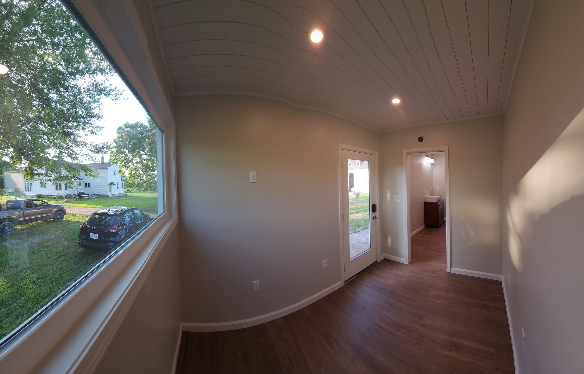 Room with large window, wood pattern floor, and with a great view of the yard.